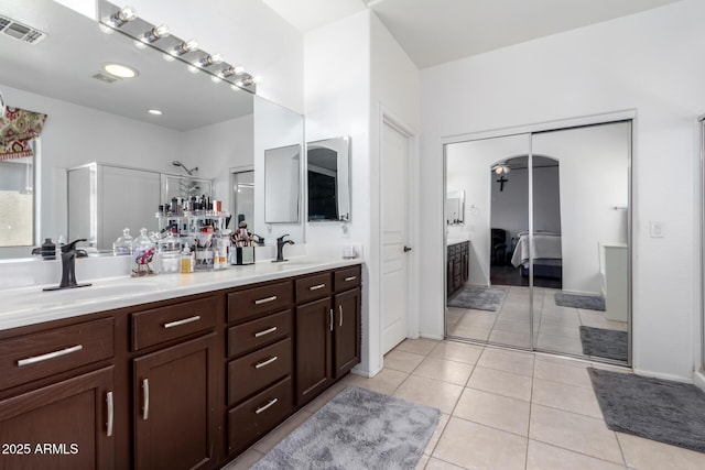 bathroom with vanity, a shower with shower door, and tile patterned floors