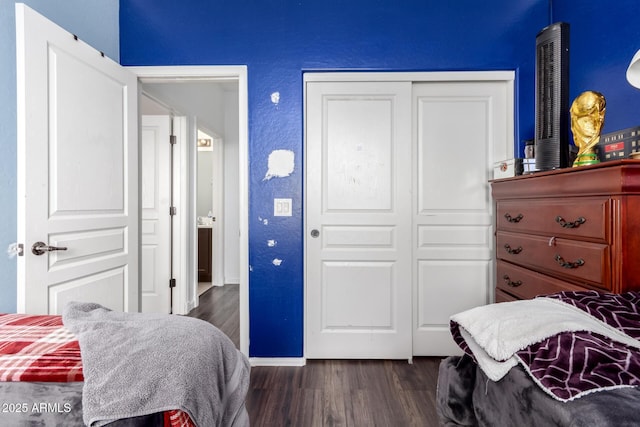 bedroom with dark wood-type flooring and a closet