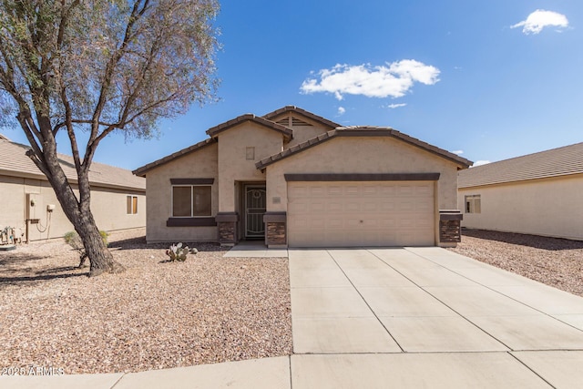 view of front of house featuring concrete driveway, an attached garage, a tile roof, and stucco siding