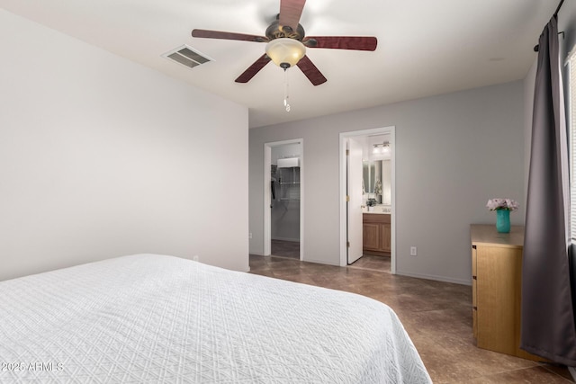 bedroom with connected bathroom, a ceiling fan, visible vents, baseboards, and a walk in closet