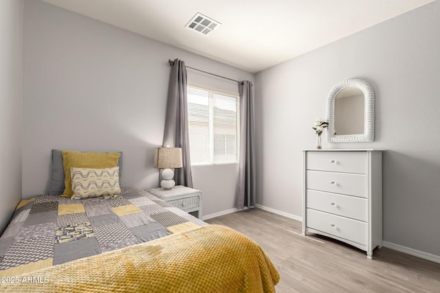 bedroom featuring light wood-type flooring, visible vents, and baseboards