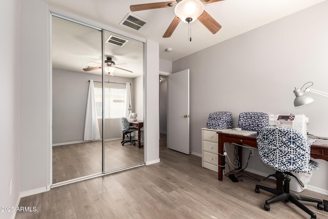 home office with a ceiling fan, baseboards, visible vents, and wood finished floors