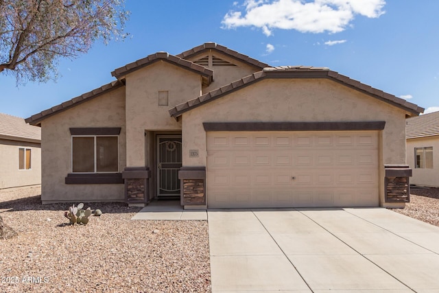 view of front facade featuring stone siding, driveway, an attached garage, and stucco siding