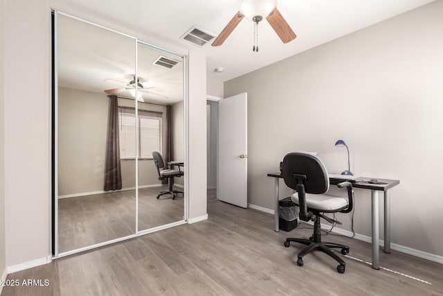 office space featuring baseboards, ceiling fan, visible vents, and wood finished floors