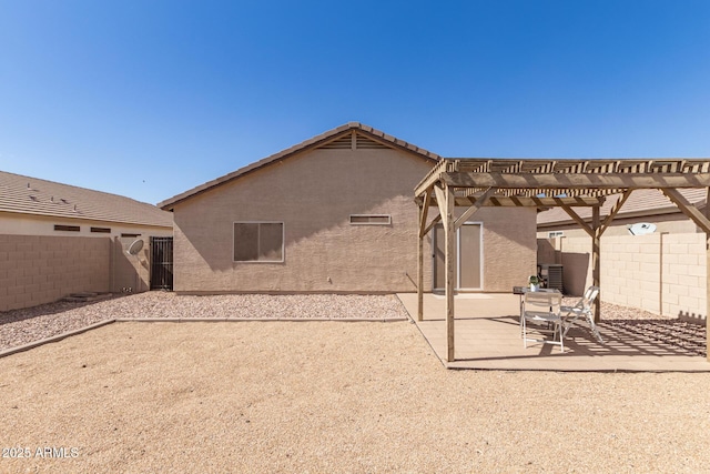 rear view of house featuring a patio, stucco siding, a fenced backyard, and a pergola