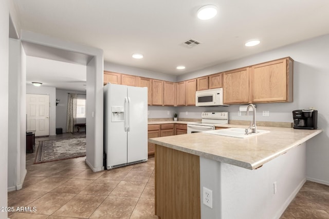 kitchen with white appliances, visible vents, a peninsula, light countertops, and a sink