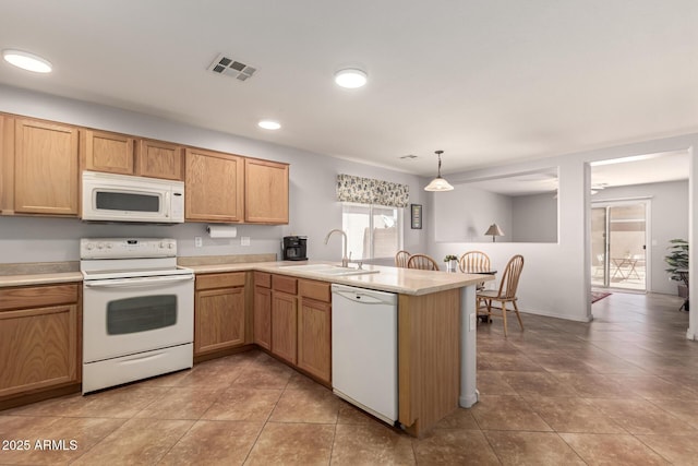 kitchen with a peninsula, white appliances, a sink, visible vents, and light countertops