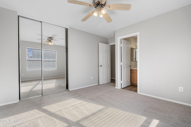 unfurnished bedroom with light carpet, ceiling fan, a closet, and ensuite bath