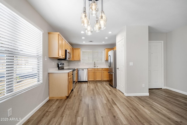 kitchen featuring pendant lighting, sink, light hardwood / wood-style flooring, appliances with stainless steel finishes, and light brown cabinetry