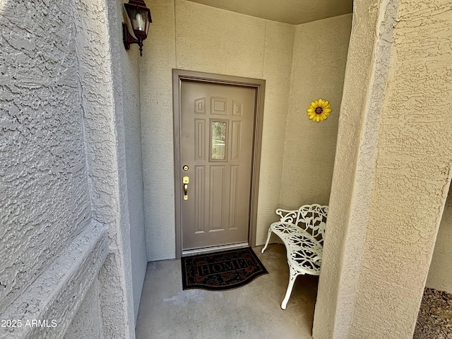 view of exterior entry featuring stucco siding