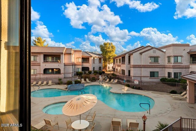 pool featuring fence, a community hot tub, a residential view, and a patio