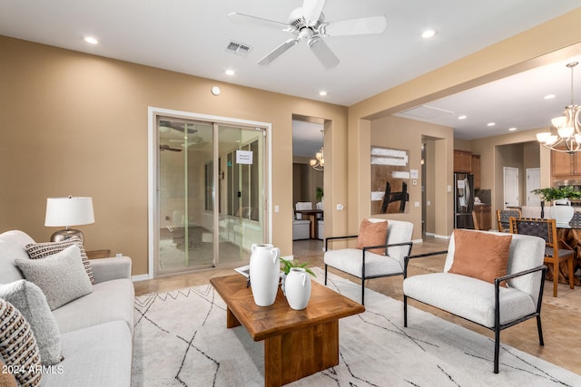 living room with ceiling fan with notable chandelier