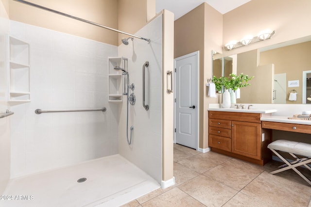 bathroom featuring tiled shower, vanity, and tile patterned flooring