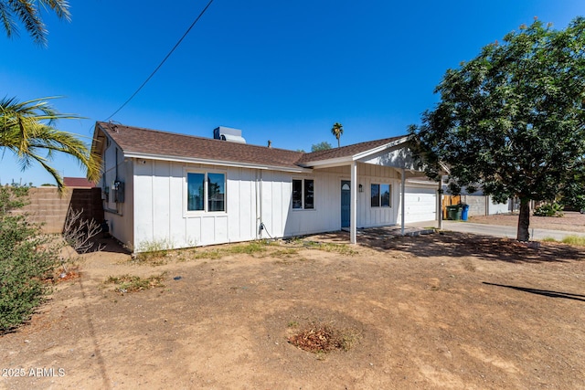 13039 N 19th Ave, Phoenix, AZ 85029 - ranch-style home featuring a garage, board and batten siding, fence, and dirt driveway