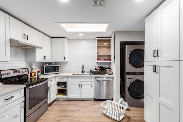 13039 N 19th Ave, Phoenix, AZ 85029 - kitchen featuring appliances with stainless steel finishes, stacked washer and clothes dryer, under cabinet range hood, a sink, and open shelves