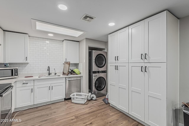 13039 N 19th Ave, Phoenix, AZ 85029 - laundry room with stacked washer and clothes dryer, recessed lighting, and light wood-type flooring