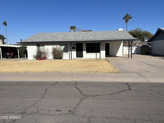 ranch-style house featuring central air condition unit and a carport