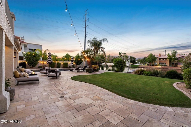 surrounding community featuring a patio, an outdoor fire pit, and a lawn