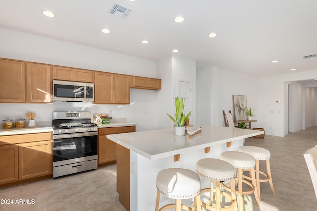 kitchen with appliances with stainless steel finishes, a center island, and a kitchen breakfast bar