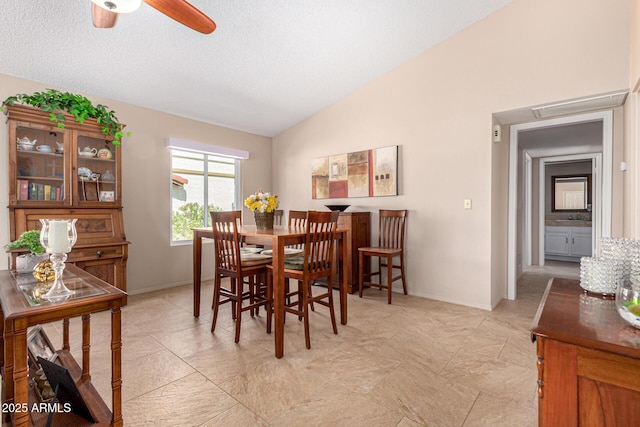 dining room with a textured ceiling, ceiling fan, vaulted ceiling, and baseboards