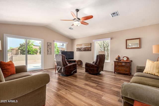 living area with visible vents, ceiling fan, wood finished floors, and lofted ceiling