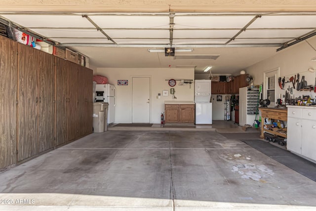 garage with a workshop area, a garage door opener, and freestanding refrigerator