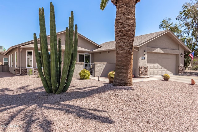 view of front facade with concrete driveway, an attached garage, fence, and stucco siding