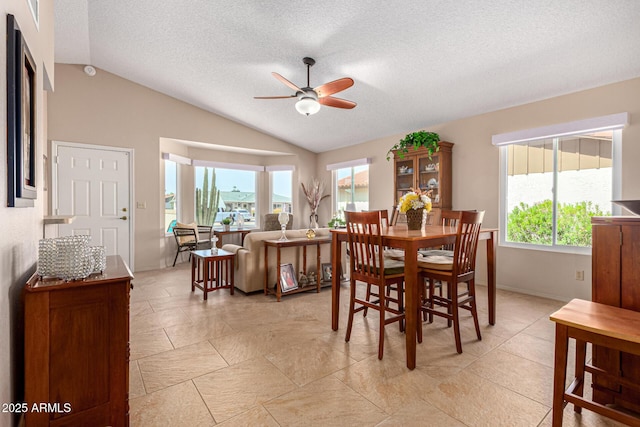 dining room with a ceiling fan, a textured ceiling, a wealth of natural light, and lofted ceiling