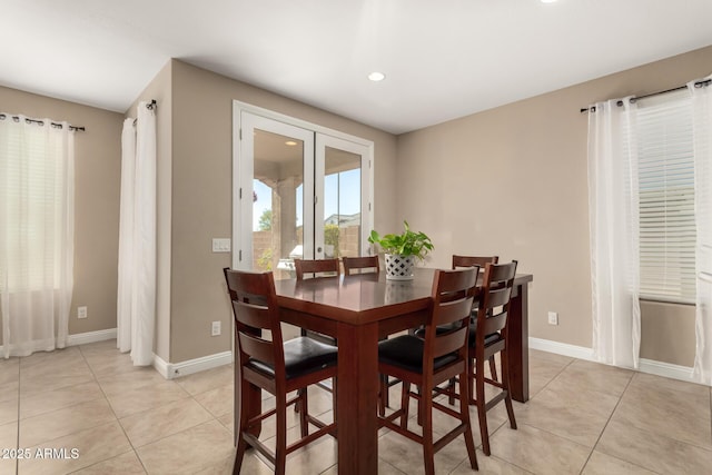 dining area with french doors and light tile patterned floors