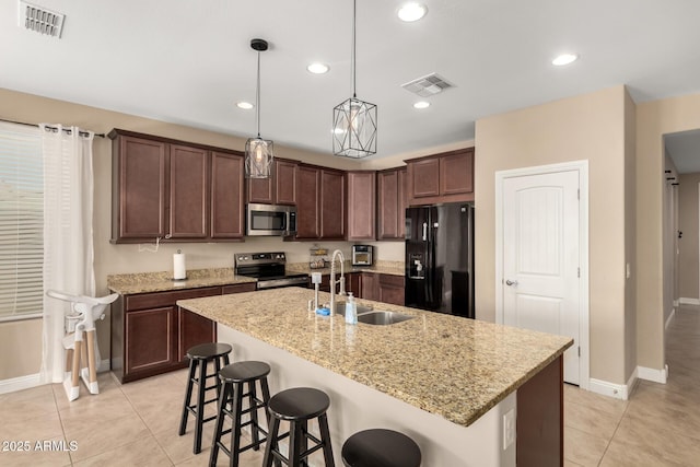 kitchen featuring appliances with stainless steel finishes, a kitchen island with sink, sink, and light tile patterned floors