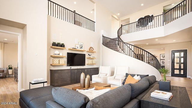 living room featuring a high ceiling and light hardwood / wood-style flooring