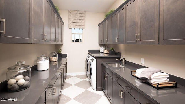 clothes washing area featuring separate washer and dryer, cabinets, and sink