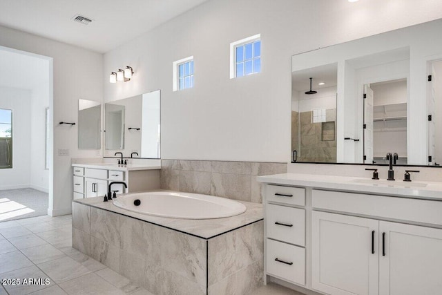 bathroom featuring tile patterned flooring, shower with separate bathtub, and vanity