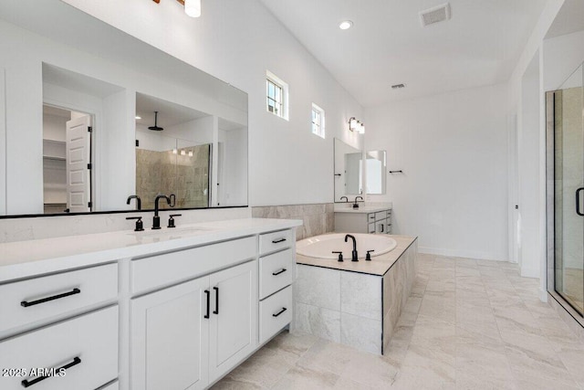 bathroom featuring vanity and independent shower and bath