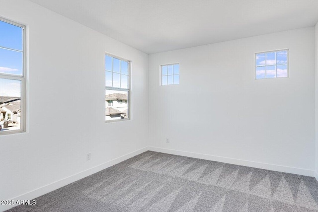 carpeted spare room featuring a healthy amount of sunlight