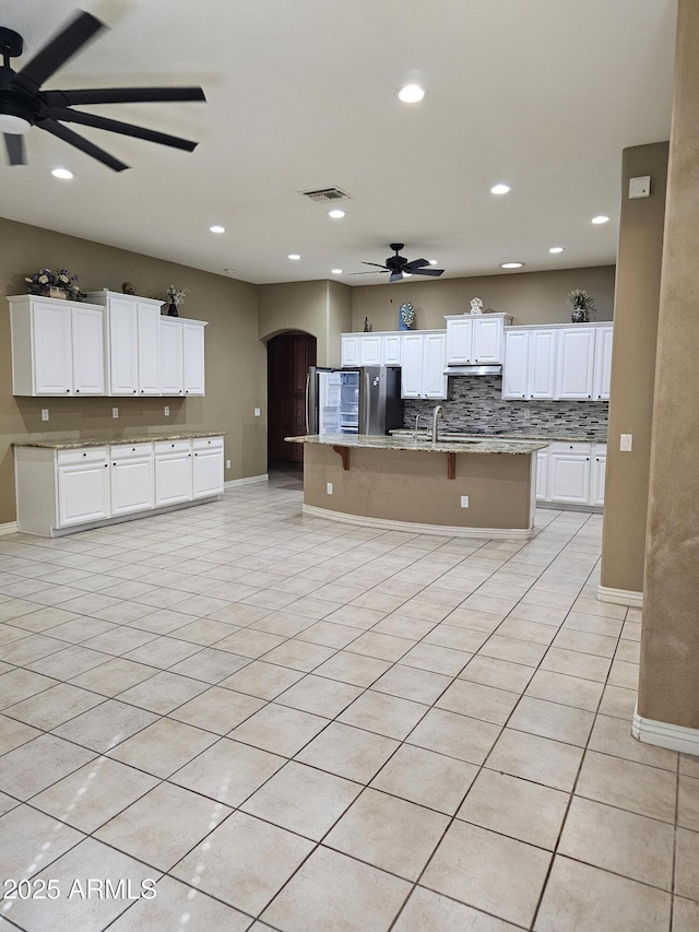 14380 W Monte Vista Rd, Goodyear, AZ 85395 - kitchen with ceiling fan, baseboards, arched walkways, white cabinets, and recessed lighting