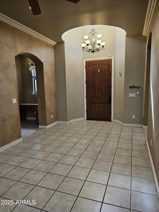 14380 W Monte Vista Rd, Goodyear, AZ 85395 - foyer entrance with arched walkways, ornamental molding, a chandelier, light tile patterned floors, and a ceiling fan