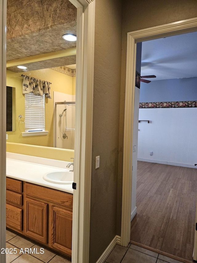 14380 W Monte Vista Rd, Goodyear, AZ 85395 - bathroom with vanity, a shower stall, ceiling fan, and baseboards