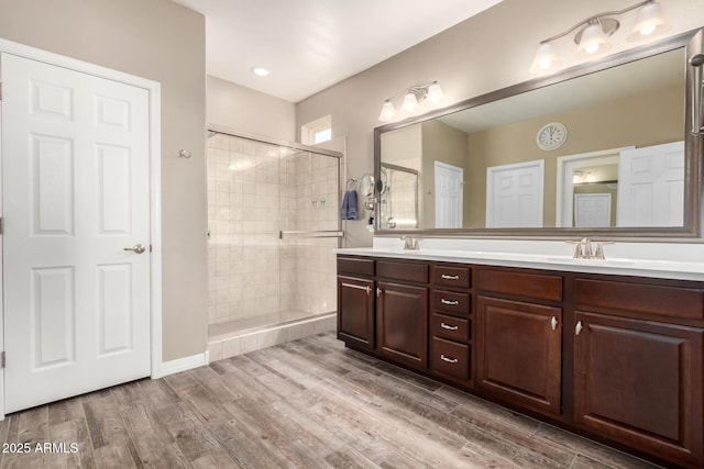 bathroom featuring vanity, hardwood / wood-style floors, and a shower with door