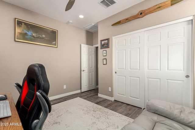 home office with dark wood-type flooring and ceiling fan