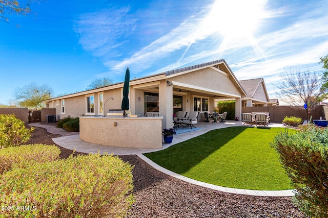 back of property featuring a patio, area for grilling, and a lawn