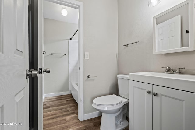 full bathroom featuring baseboards, toilet, bathtub / shower combination, vanity, and wood finished floors