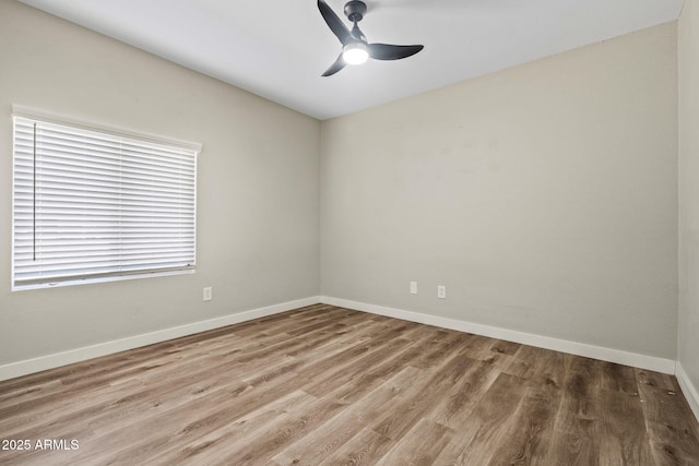 empty room featuring wood finished floors, ceiling fan, and baseboards