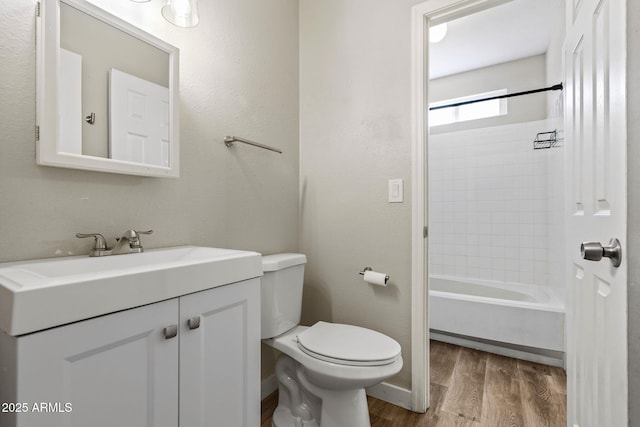 bathroom featuring vanity, baseboards, shower / bath combination, toilet, and wood finished floors