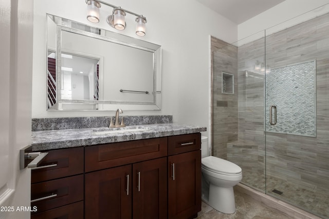 full bath with vanity, a shower stall, and toilet