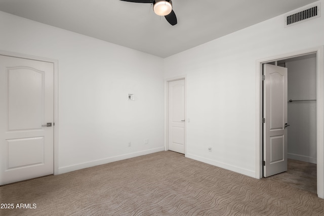 unfurnished bedroom featuring carpet floors, baseboards, visible vents, and ceiling fan