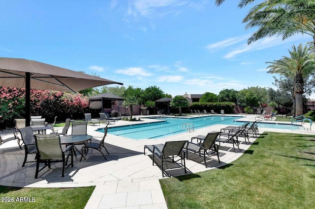 community pool with a patio area, fence, and a yard