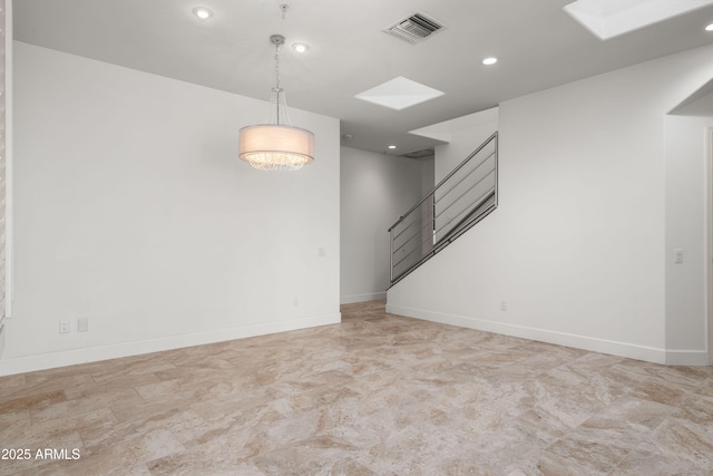 unfurnished room with stairway, baseboards, a skylight, and visible vents