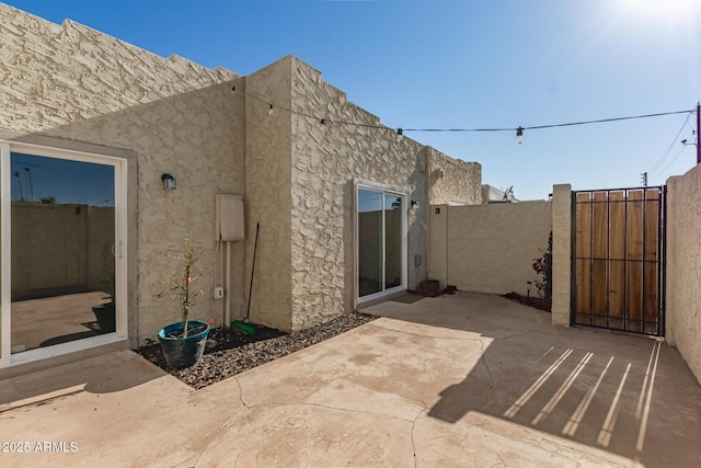 4722 W Via Cynthia, Glendale, AZ 85301 - back of house featuring stucco siding, a gate, and a patio