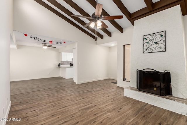 4722 W Via Cynthia, Glendale, AZ 85301 - unfurnished living room featuring a ceiling fan, beamed ceiling, wood finished floors, a large fireplace, and high vaulted ceiling